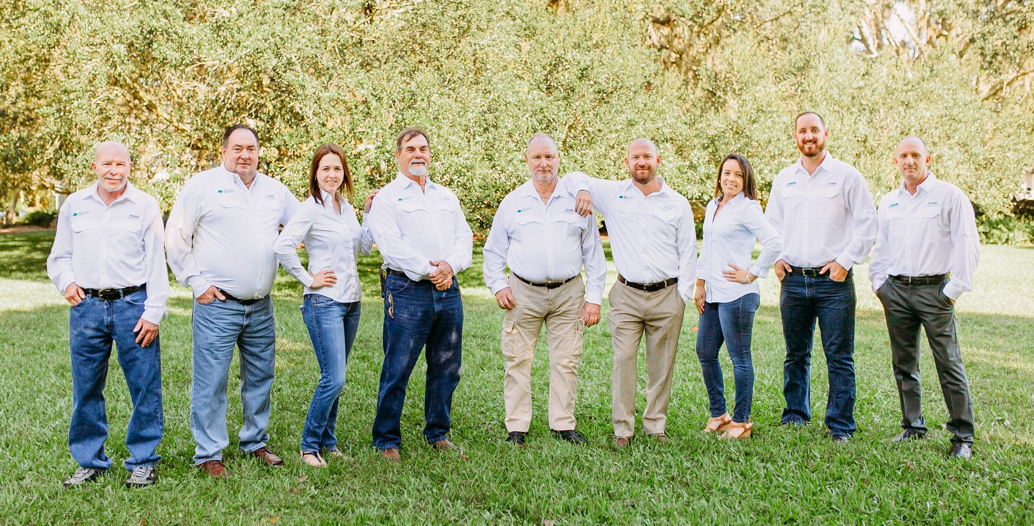 A picture of the entire McFall Roofing, a roofing company, wearing white shirts