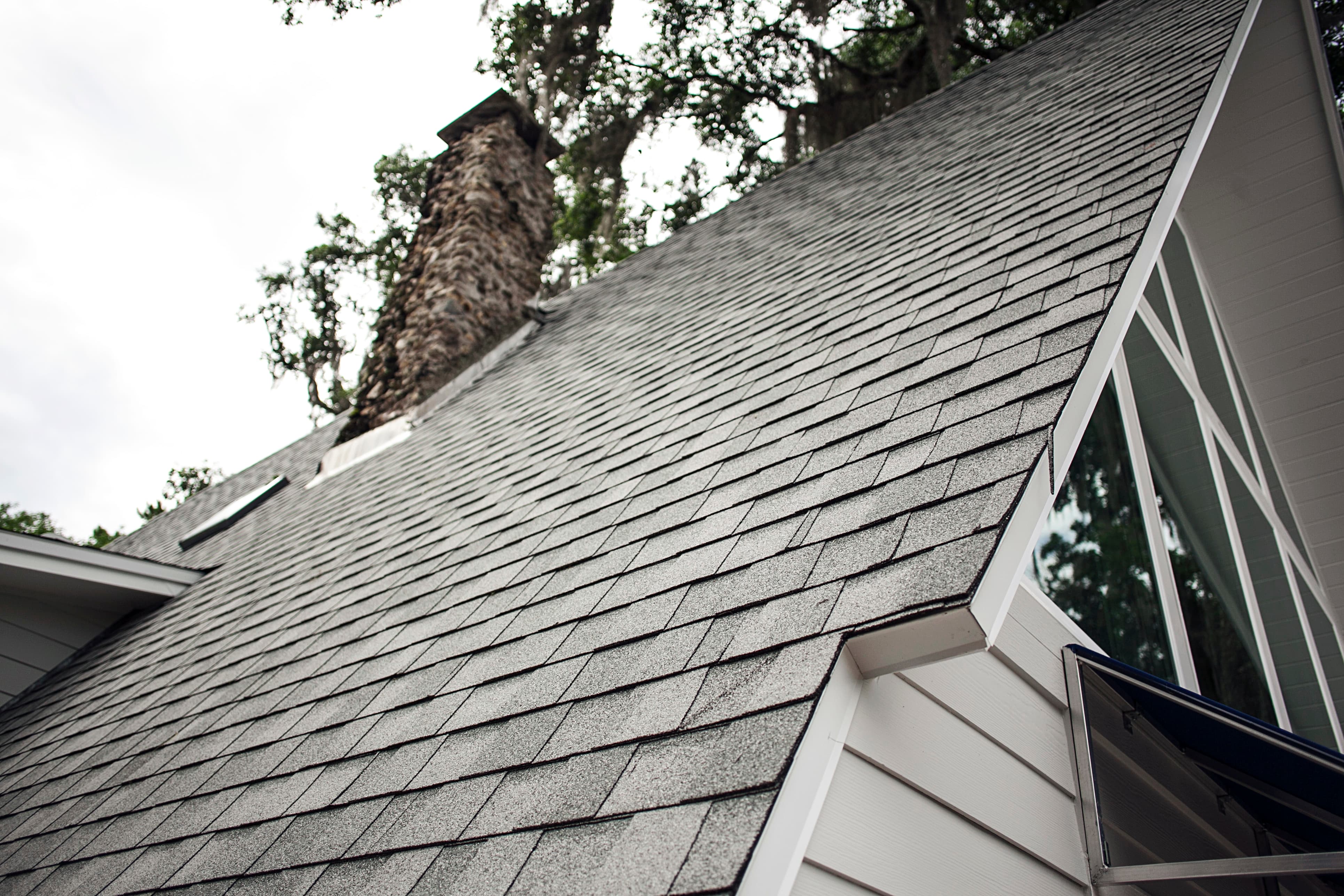 Roofing Emergencies - A picture of a sloped residential roof with asphalt shingles.